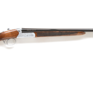Shotgun with polished wooden stock and blued barrel, featuring intricate silver engravings on the receiver.