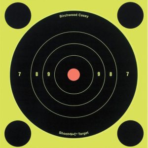 Yellow and black Birchwood Casey shooting target with concentric circles and a red bullseye, labeled "Shoot•N•C Target."