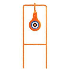 Bright orange gun target with a circular design featuring a black crosshair, blue outer ring, and central yellow square, mounted on a matching orange stand.