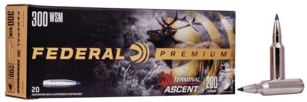 Federal premium 300 wsm ammo box with deer imagery, gold and black design; two silver bullets with blue tips displayed alongside.