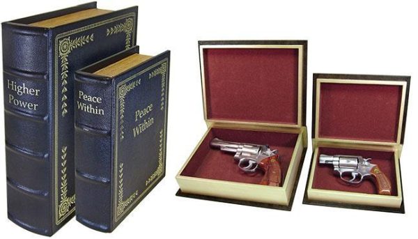 Two faux book boxes with titles "higher power" and "peace within," open to reveal handguns with silver finishes and wooden grips inside red velvet-lined interiors.