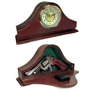 Wooden mantel clock with a concealed compartment revealing a silver revolver and black ammunition box inside, highlighted by a green velvet lining.