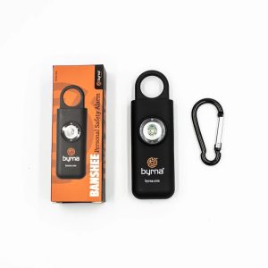 Byrna Banshee personal safety alarm, black with a built-in light, next to its orange packaging and a black carabiner.