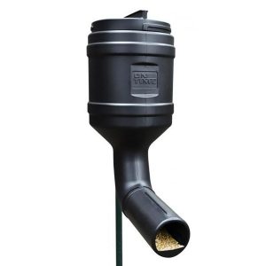 A black automatic wildlife feeder with a cylindrical top and angled spout, dispensing corn.