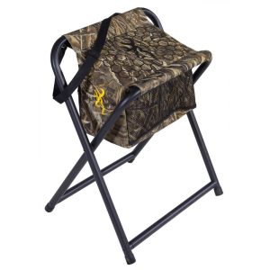 Camouflage folding chair with a storage bag, featuring a yellow logo on the fabric, black metal frame, adjustable strap, suitable for hunting or outdoor activities in Casey, Iowa.