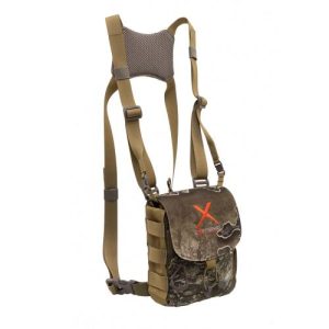 Tan and camouflage harness-style bag with adjustable straps and mesh padding, featuring an orange "X" logo on the front flap.