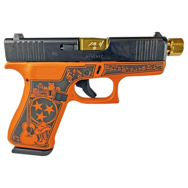 Customized glock handgun with an orange and black grip featuring engraved musical notes, a city skyline, and a guitar design. The barrel is gold, and the firearm is photographed against a white background.