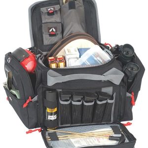 Black and gray firearm range bag with multiple compartments, containing ammo boxes, binoculars, cleaning rods, and a red first aid kit.