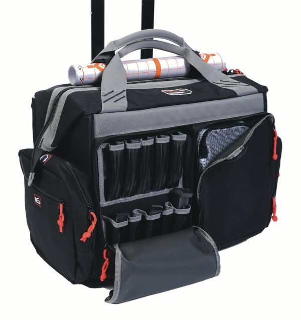 Black and gray tactical bag with multiple compartments, red zipper pulls, and mesh pocket, designed for firearms and ammo storage, featuring a roll of paper secured on top.