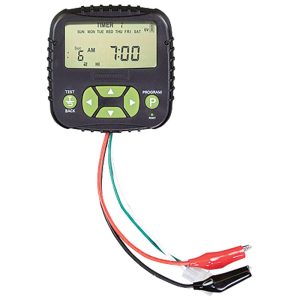 A digital timer with a black casing and green buttons, featuring red, white, and green wires with alligator clips.
