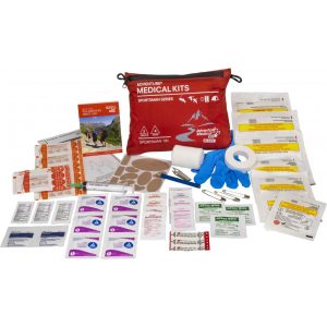 Medical kit contents spread out, featuring a red Adventure Medical Kits bag, gauze, gloves, bandages, and various medical supplies.