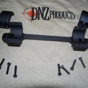 Black scope mount with multiple screws on a beige cloth featuring the DNZ Products logo.