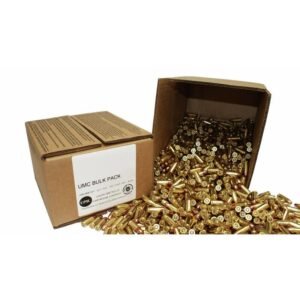 Cardboard box labeled "umc bulk pack" with numerous shiny brass and copper ammunition rounds spilling out.